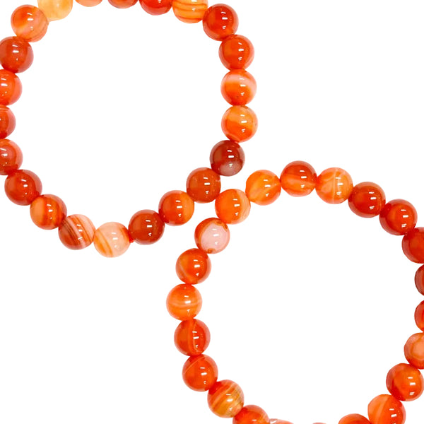 Two strands of carnelian bead bracelets with varying shades of orange and red, displayed against a white background.