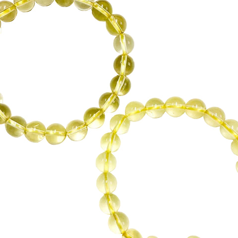 A close-up image of a yellow citrine bracelet with elastic stretching cord, displaying the gemstone beads.