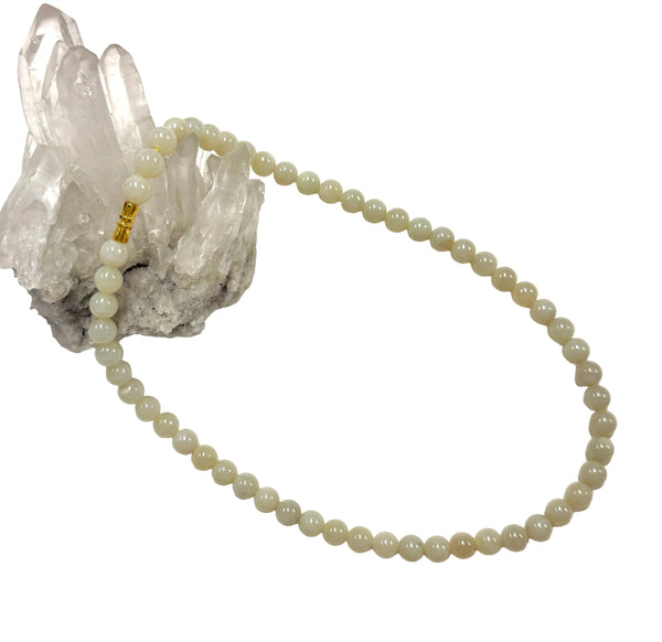 Jade necklace on a white background with a crystal formation.