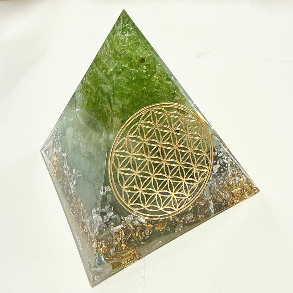 Large Pyramid Orgonite | Peridot, Prehnite, Aventurine | Heart, Base Chakras crystal pyramid with a gold flower of life geometric design on a white background