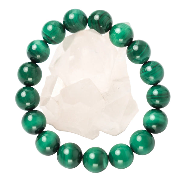 A green Malachite bracelet with bead sizes approximately 12mm, displayed on a white crystal.