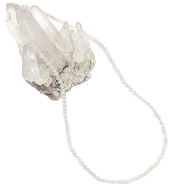 A  moonstone necklace laid out on a white surface