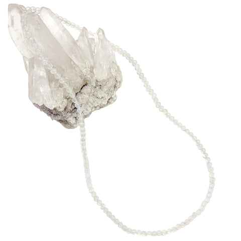 A  moonstone necklace laid out on a white surface