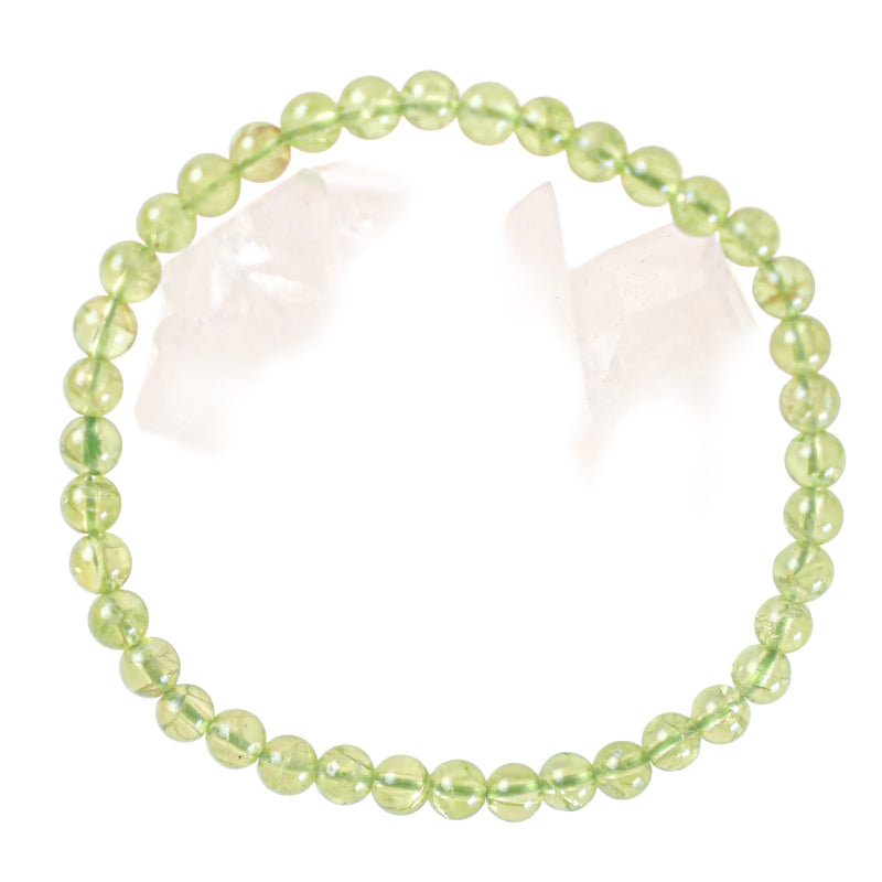 A green peridot bracelet with 4mm beads displayed on a white surface.