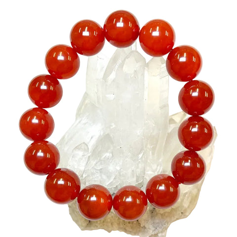 A red agate bead bracelet with a series of round beads on a crystal