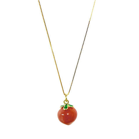 Necklace with a red agate peach pendant and green leaves on a white background