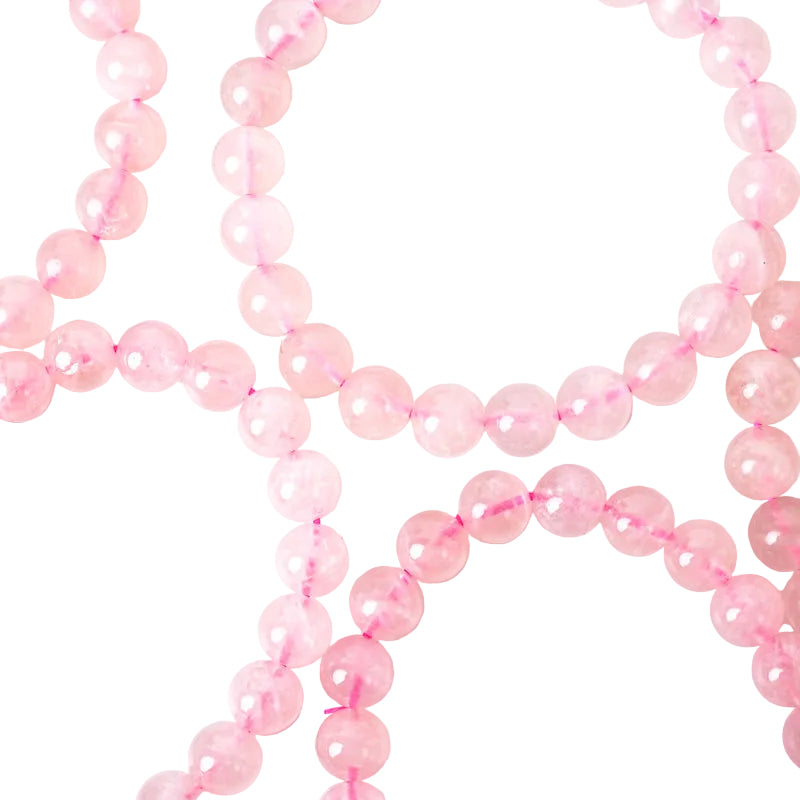 A close-up image of a rose quartz bracelet with pink beads and an elastic stretching cord.