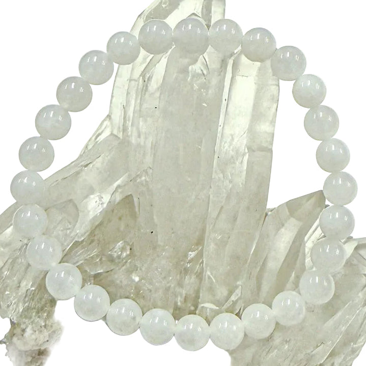 A white jade bracelet displayed on a crystal stand, consisting of round beads approximately 6mm in size.