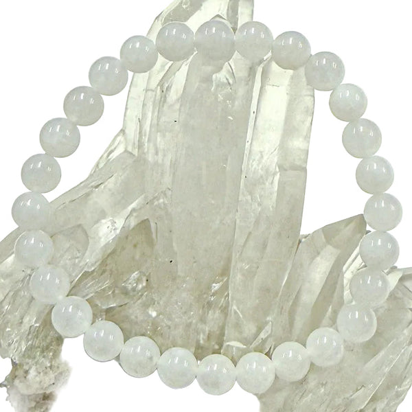 A white jade bracelet displayed on a crystal stand, consisting of round beads approximately 6mm in size.