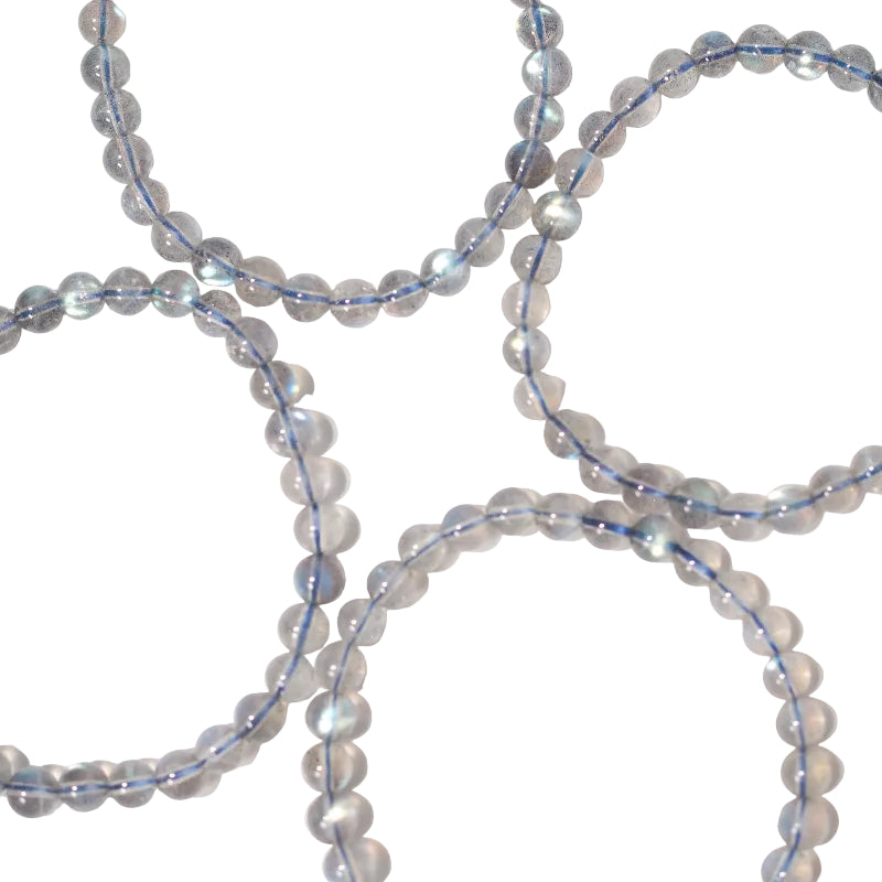 A series of round labradorite beads with blue and white light reflections, strung on an elastic cord.