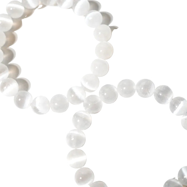 A bracelet made of white selenite beads with an elastic stretching cord, displayed on a light background.