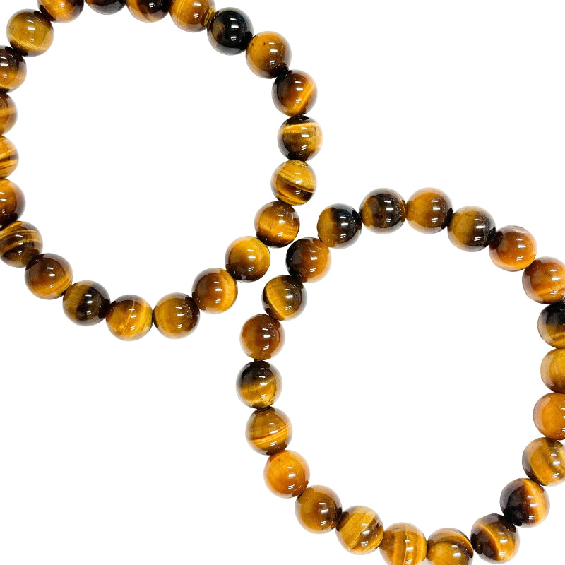 A Tiger Eye bracelet with beads of varying shades of brown and black, laid out on a white surface.